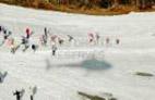  - Photo réf. 62047_12 - Les spectateurs en bordure de piste et l'ombre de l'hlico sur la neige.