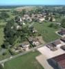 Photos aériennes de "place" - Photo réf. 15038 - Le village aux sources, possde une glise avec nef ancienne. La place s'embellit de murs de pierre, la mairie et le gymnase sont neufs, bref, l'aspect du village est transform.