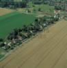 Photos aériennes de "champs" - Photo réf. 57245 - Alignée le long de la route et face aux champs, une rangée de maison.